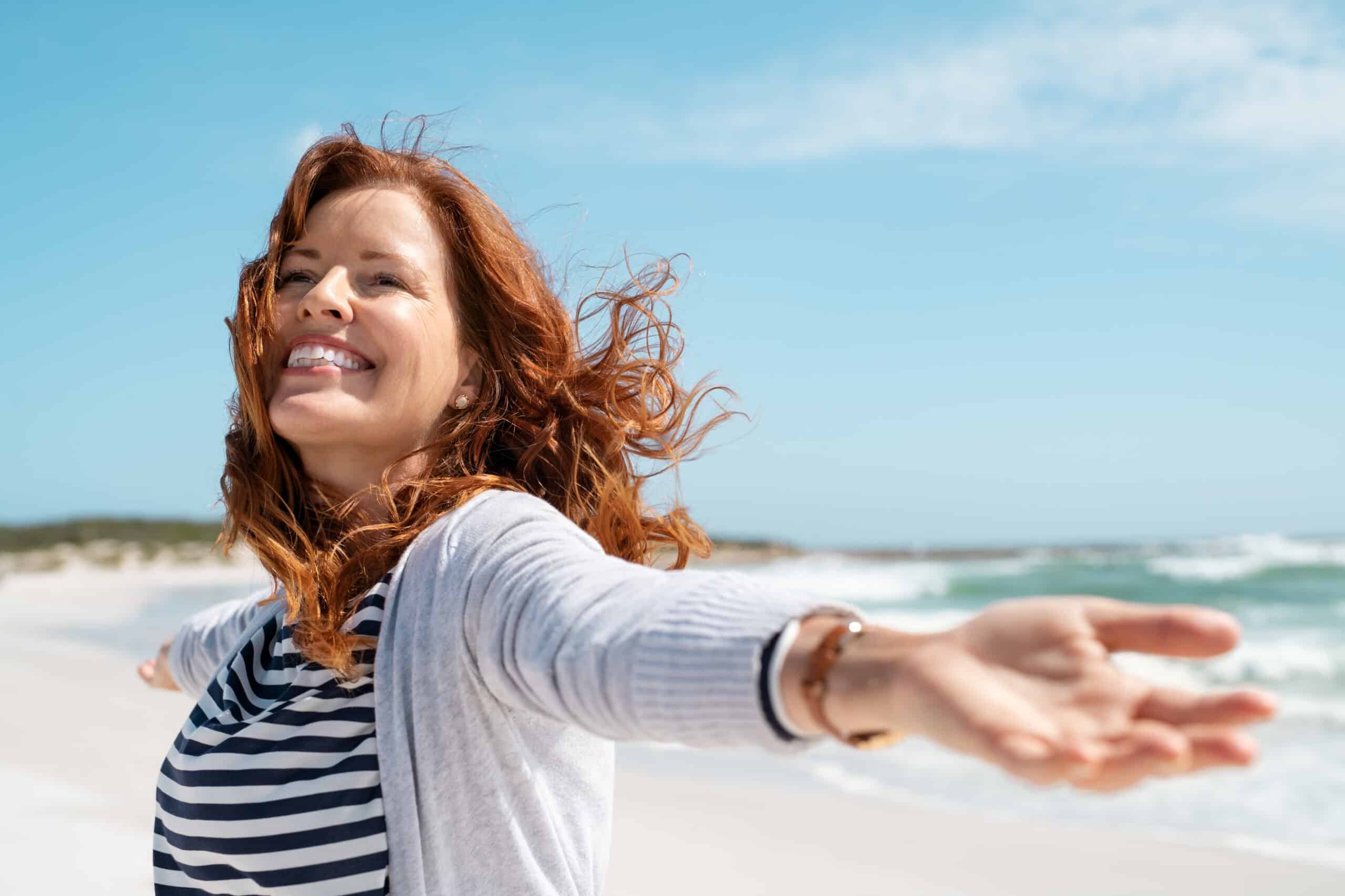 Happy,Mature,Woman,With,Arms,Outstretched,Feeling,The,Breeze,At